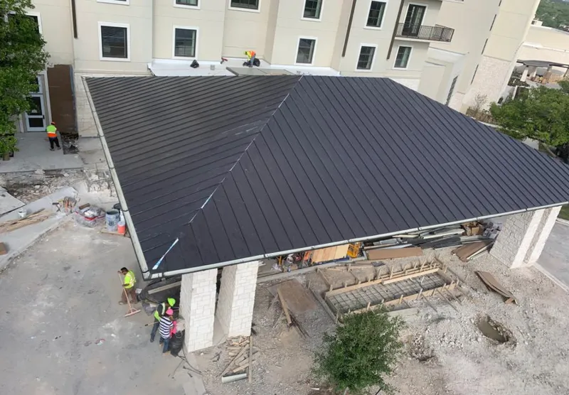 Metal roofing installation team working on a commercial building in Justin